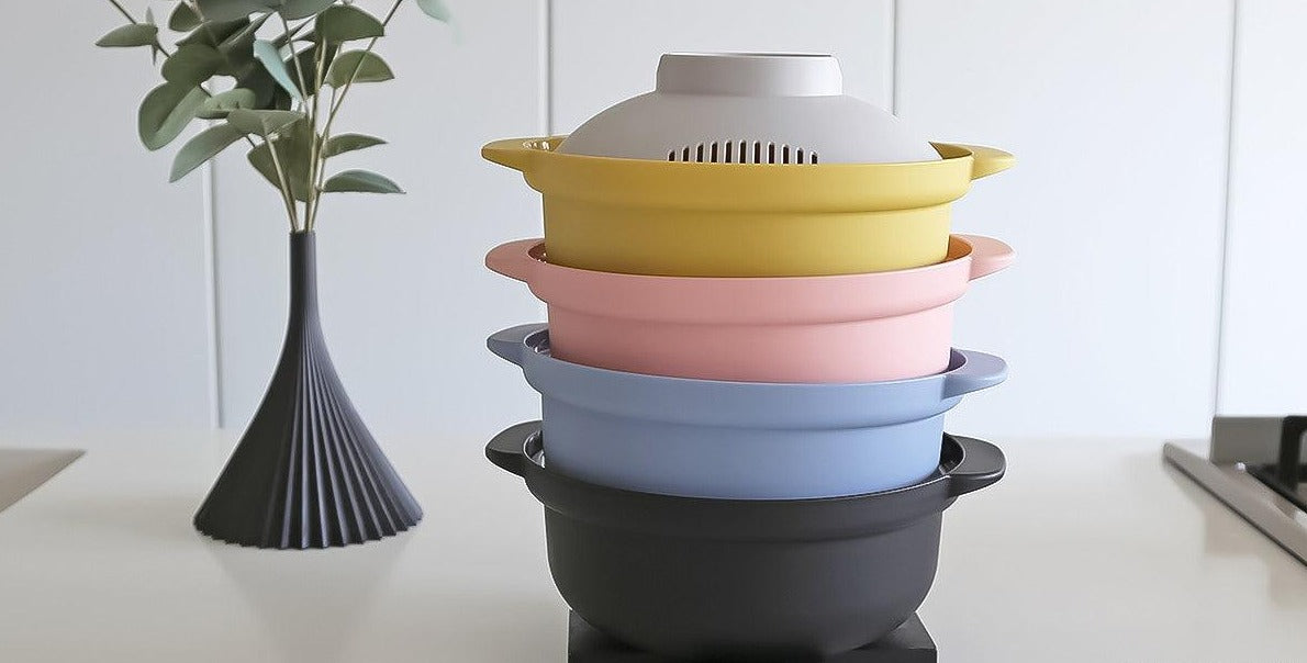 Four Microwave cookware pot stacked front black blue pink yellow