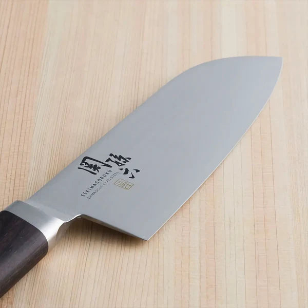 KAI Sekimagoroku Damascus Stainless Steel Santoku Kitchen Knife on wooden chopping board