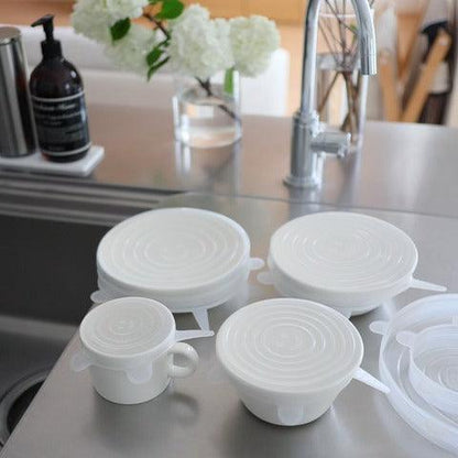 Silicone food wrap on 4 different white ceramics by sink